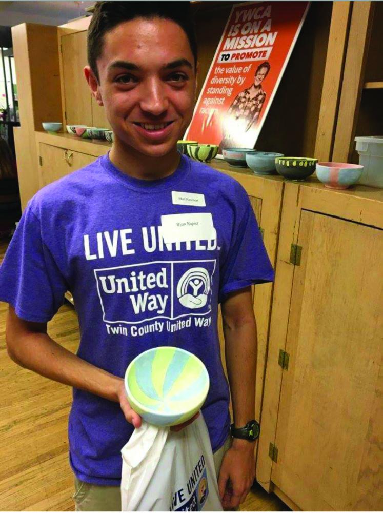 Ryan Rapier poses with his bowl that he made during the Day of Caring. Photo courtesy of United Way Facebook.