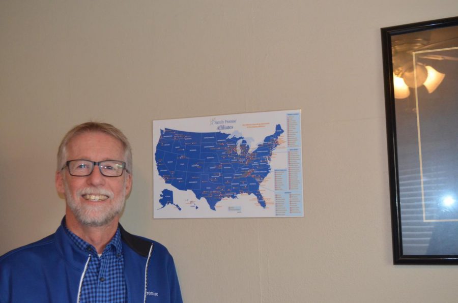 Steve Thomas, the executive director of Family Promise posing next to a map that marks all of the other Family Promise branches. Photo by Loretta Tuell.