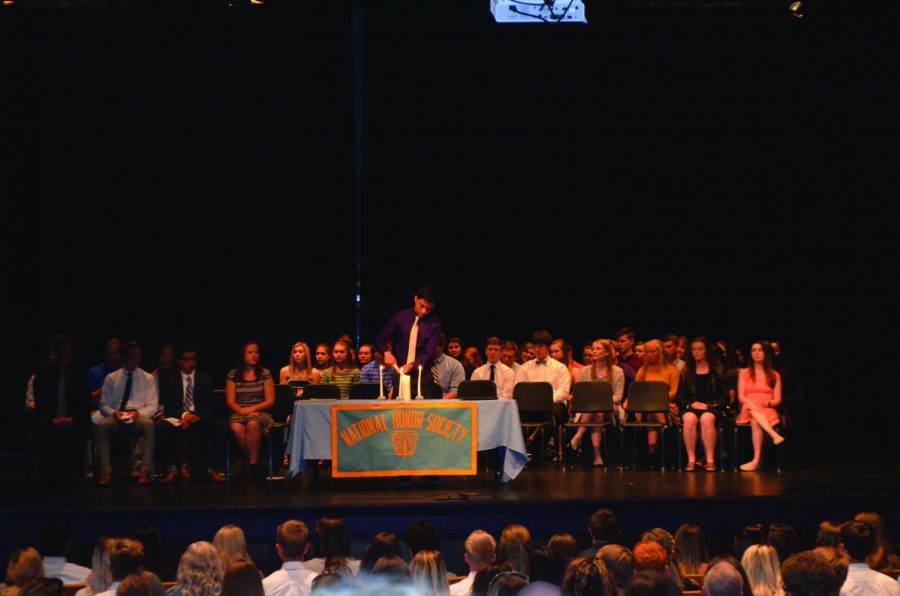 NHS inductee lights candles as part of an induction ceremony May 2. 
