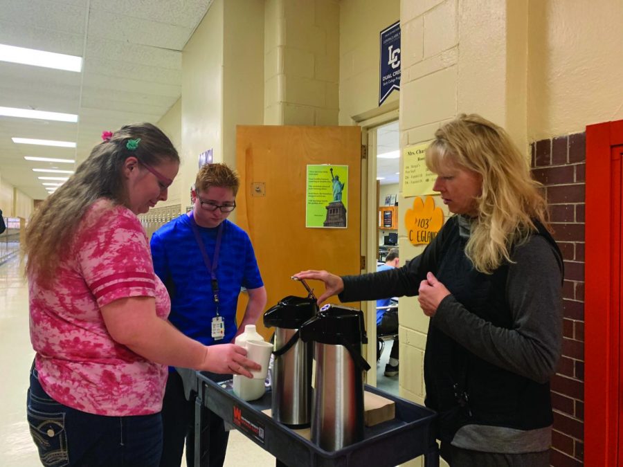 Two Life Skills students (left) help prepare coffee for a teacher as a part of the new coffee cart service. Photo by Kim Neri.