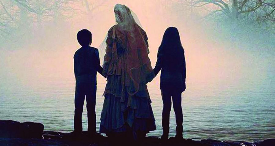 La Llorona stands near the river with children, dressed in white garments. Photo courtesy of HeraldNet.