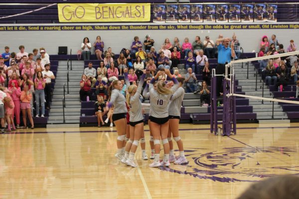 Varsity volleyball team circles up before a match. Photo by Heidi Rowell 