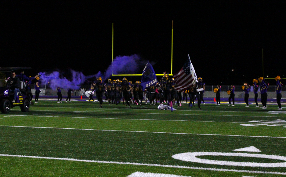 Lewiston Bengals Football team crashing through run through poster led by school admin on Bengals golf cart with smoke bombs