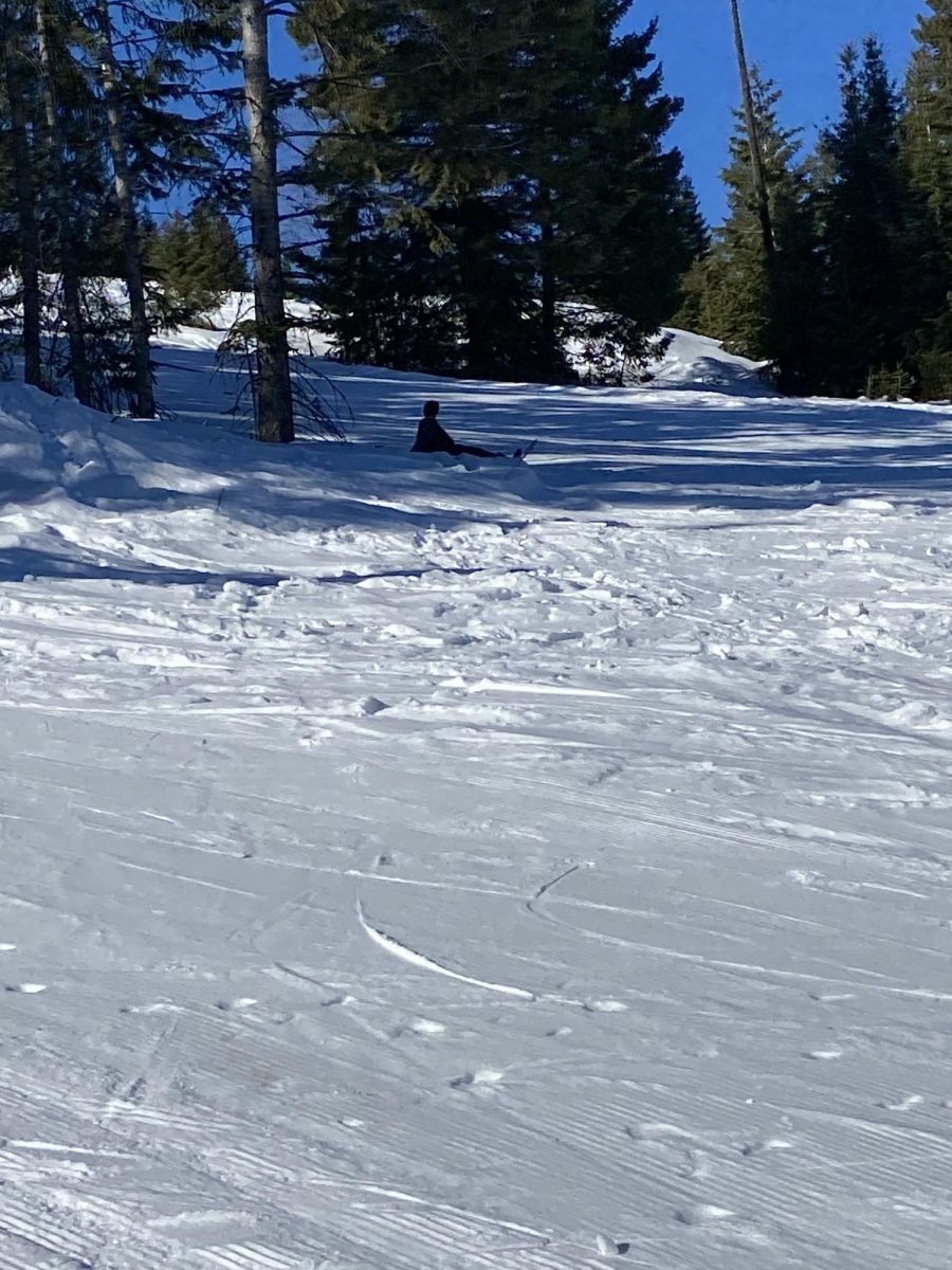 Snowboarder rests on a run next to the T-bar at Snowhaven